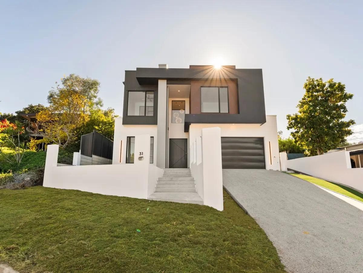 Contemporary two-storey home in Camp Hill with charcoal upper cladding and white rendered base.