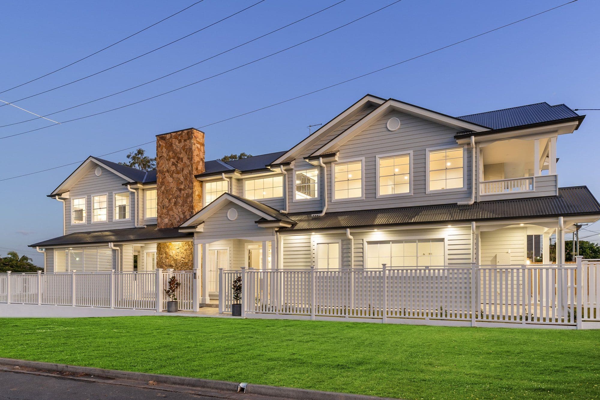 A custom Hamptons style home demonstrating premium corner block house designs in Brisbane, featuring a wrap-around facade.