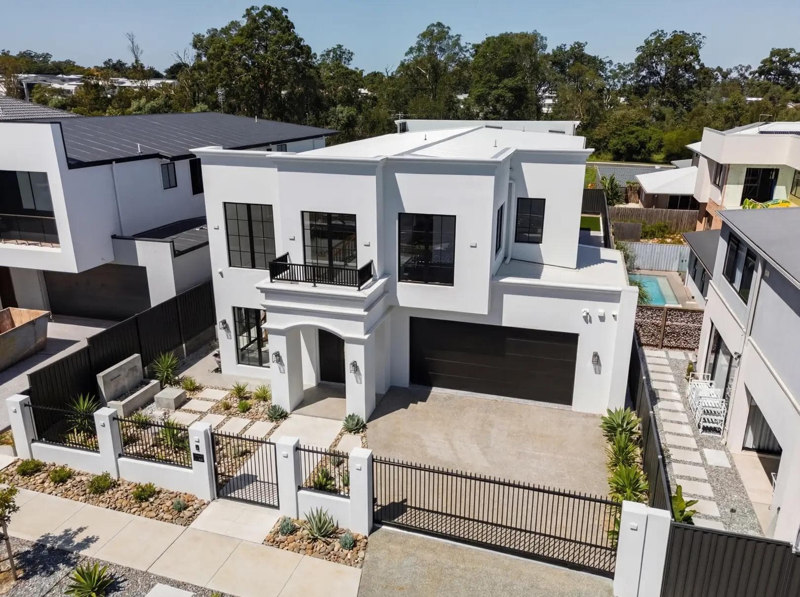 A modern white custom home featuring black window framing, built by design and construct builders in Brisbane.