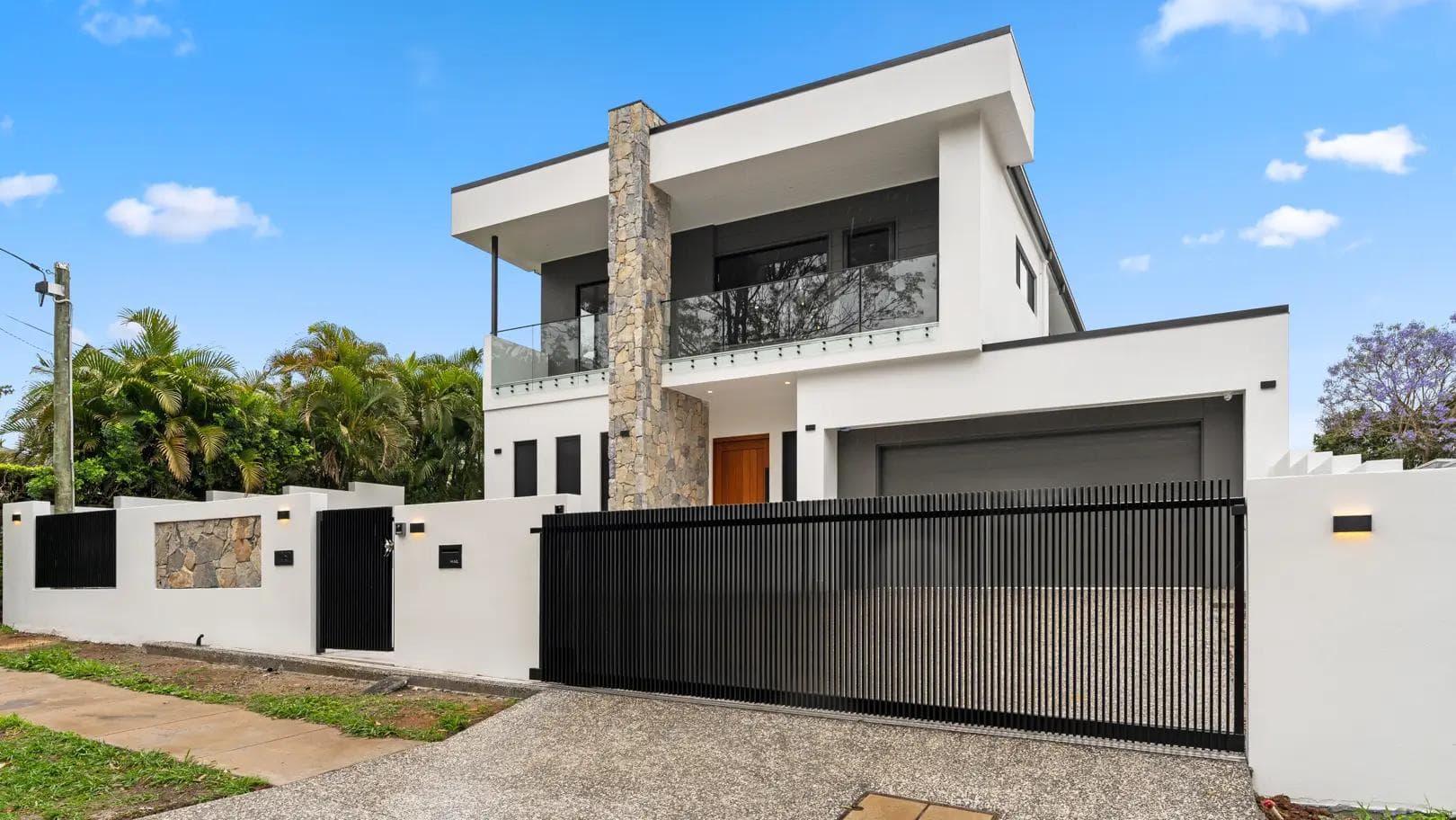 Contemporary two-storey home in Mount Gravatt East with stone feature pillar and black slatted gate.