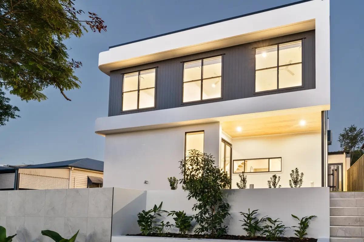 Two-storey Hamptons style custom home facade in Brisbane featuring weatherboard cladding and gable roof