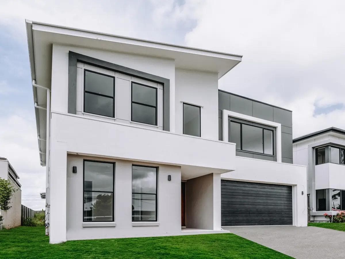Modern two-storey home in Rochedale with rendered facade and dark cladding accents.
