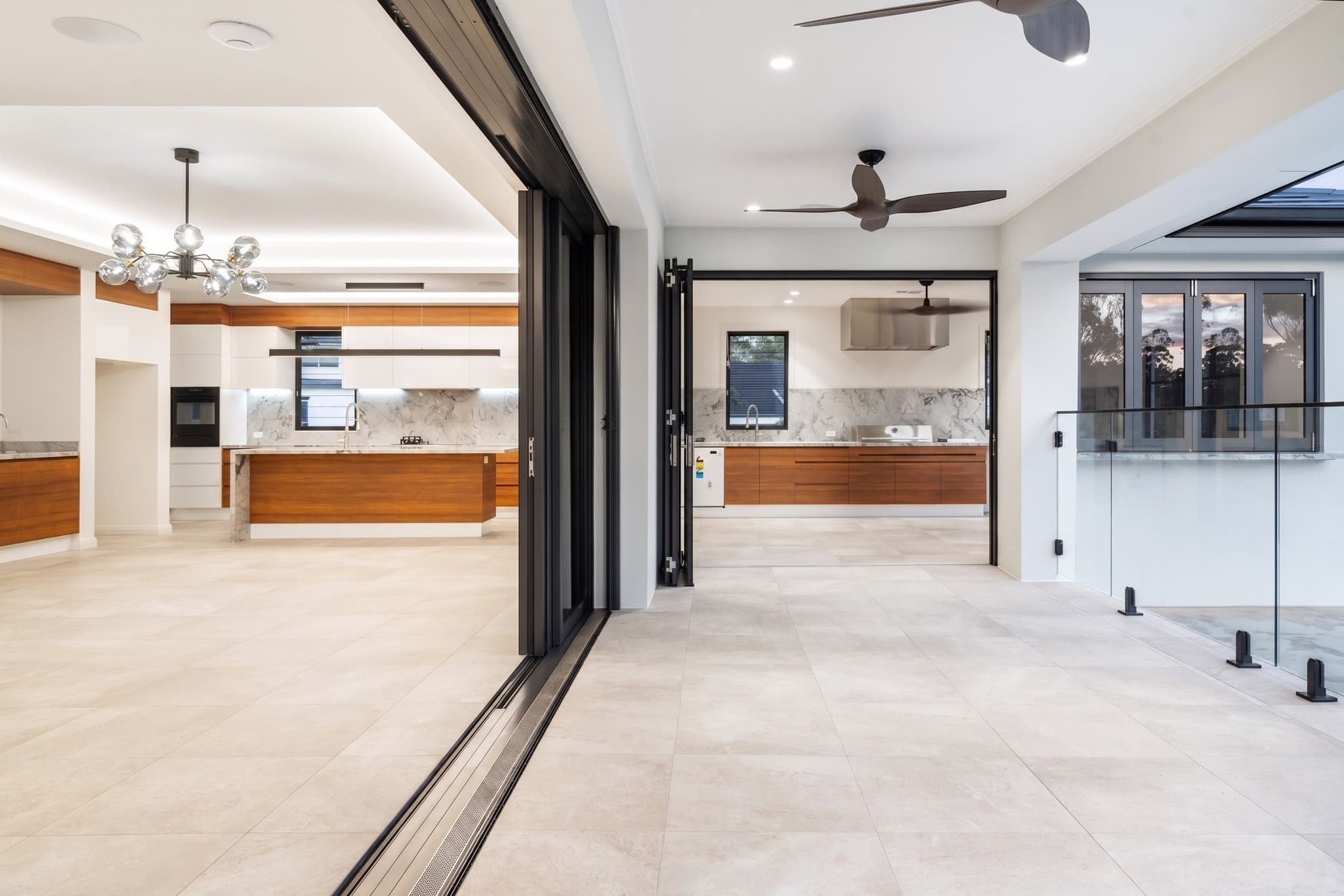 Custom luxury house design in Brisbane featuring expansive sliding doors opening to a covered alfresco area.