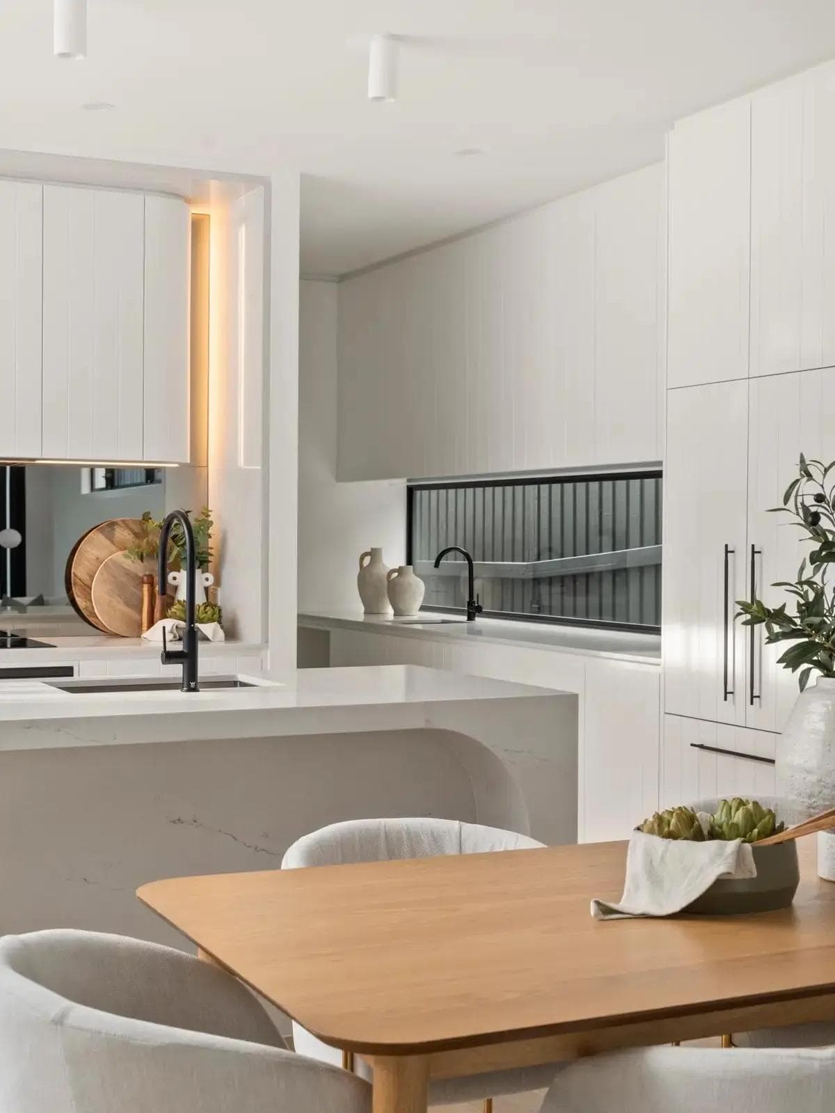 Curved stone island bench and custom joinery in the kitchen at Pavo House in Camp Hill, a custom home built by Flascon