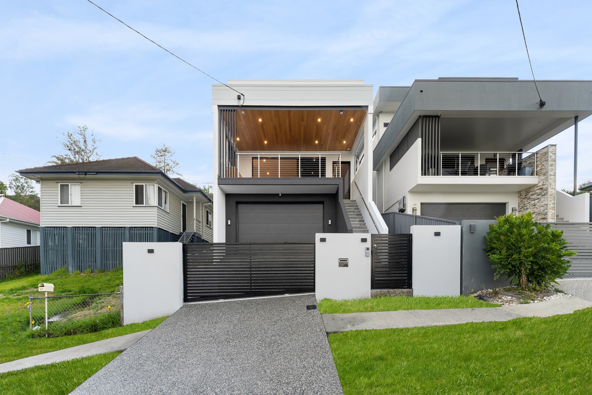 Completed two-storey Brisbane home built on a sloping block, with the garage tucked beneath an elevated main living level accessed by an external staircase